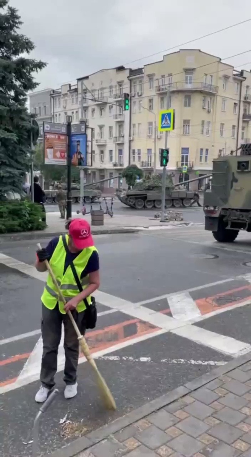 Dos personas barren tranquilamente las calles rodeadas de tanques en Rusia